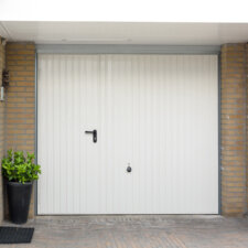 Witte Hörmann kanteldeur met ingebouwde loopdeur | Brabant Deur